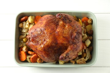 Delicious baked turkey and vegetables in baking dish on white wooden table, top view