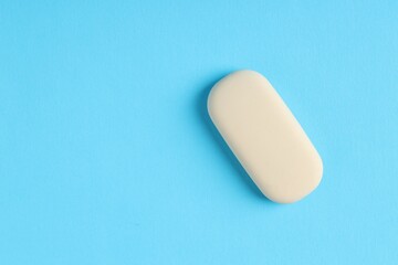 One eraser on light blue background, top view. Space for text