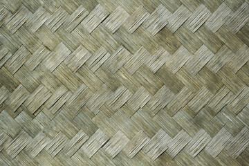 Beautiful weaving pattern made from natural materials such as bamboo or palm leaves, traditional crafting technique often used in various cultures to create wall coverings, mats, or decorative panels.