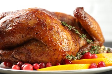 Delicious baked turkey, orange slices, cranberries and thyme on table, closeup