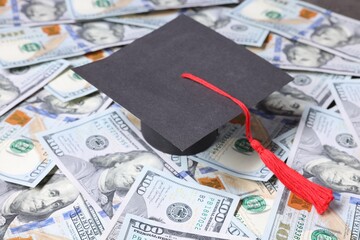 Graduate hat and dollars on table. Tuition payment
