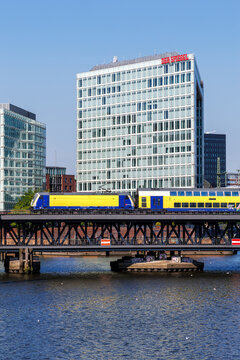 Metronom regional train public transport on the Oberhafen bridge with Der Spiegel headquarters portrait format in Hamburg, Germany