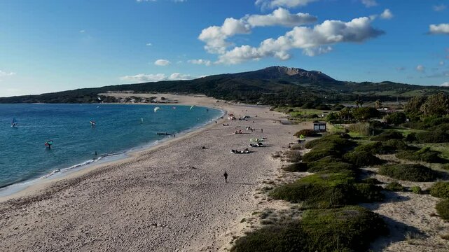 Ein kleiner Schwenk &uuml;ber den Valdevaqueros Strand in Tarifa. Der Blick zeigt die untergehende Sonne, den Ozean und die Silhouette  Horizont. Sanfte Wellen brechen am Ufer, w&auml;hrend der Him