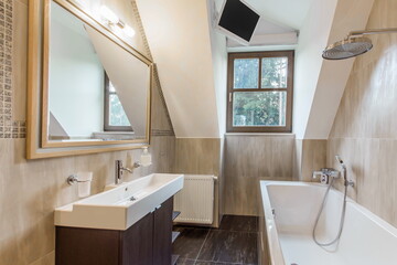 The elegant interior of the bathroom, decorated in pastel colors. Stylish accessories, TV, window with a view of the natural landscape.