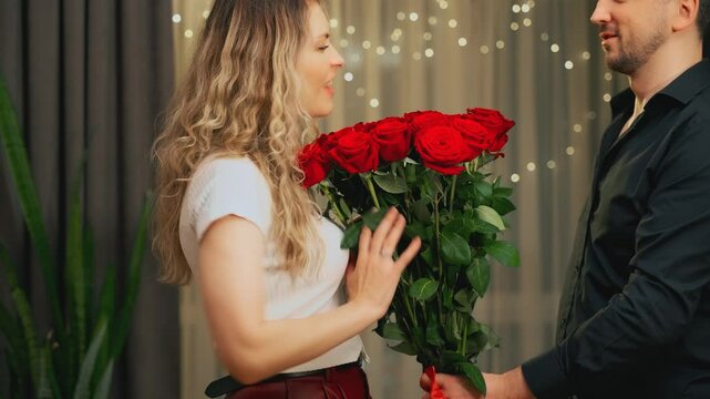 guilty man apologize gives a gift flowers red roses to woman throws away bouquet. couple problems crisis in family relationship. Angry upset girl screaming waving hands chasing guy out of home room