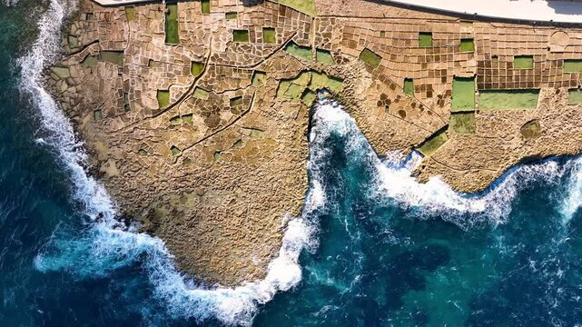 4k Aerial view of Salt flats showcase intricate patterns and vibrant colors under bright sunlight in island Gozo. Malta