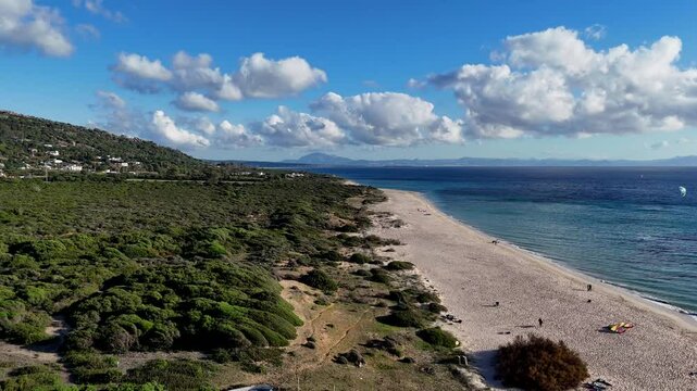 Ein kleiner Schwenk &uuml;ber den Valdevaqueros Strand in Tarifa. Der Blick zeigt die untergehende Sonne, den Ozean und die Silhouette von Afrika am Horizont. Sanfte Wellen brechen am Ufer, w&auml;hrend der Him