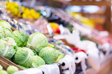 Fresh ripe cabbage heads on the counter in a supermarket.