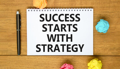 Naklejka premium Success starts with strategy symbol. Concept words Success starts with strategy on beautiful white note. Beautiful wooden background. Business and success starts with strategy concept. Copy space.