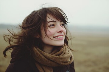 Fototapeta premium Woman smiling in a windy field during winter