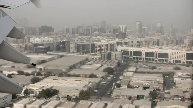 View from an airliner at the wing as it passes the city of Dubai, UAE before coming in for landing.