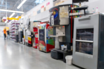 Blurred defocused image of paint mixing equipment in a construction supermarket