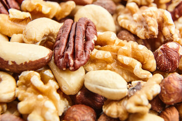 Detailed macro view of assorted nuts featuring pecans, walnuts, Brazil nuts, hazelnuts, cashews, and almonds. Perfect for healthy snacking or cooking