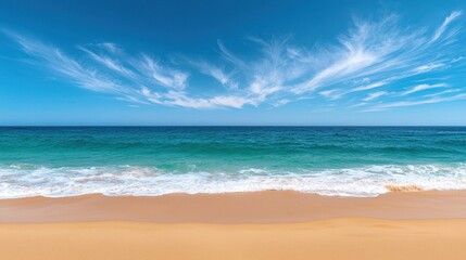 Fototapeta premium A serene beach scene featuring soft sand, gentle waves, and a clear blue sky with wispy clouds.