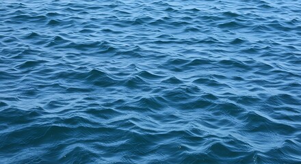 Fototapeta premium Sea abstract or rippled water texture background. Tranquil water surface texture featuring splashes and waves. Abstract nature backdrop. Surface of blue ocean water.