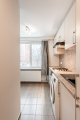 Modern Home Kitchen Interior with Cabinetry and Appliances for a Functional Design. Laundry, Oven, Tiled Floor