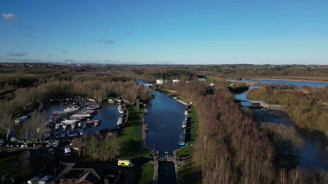 Aerial drone footage retreating over Lemonroyd Marina and Waterside beside the Aire and Calder Navigation. Canal boats and house boats moored. West Yorkshire, UK