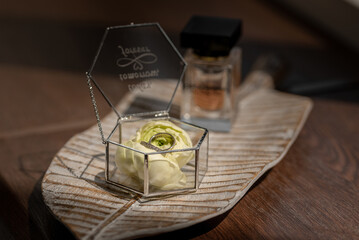 still life with a bottle of perfume and wedding rings