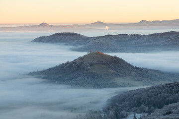Blick vom Breitenstein, Ochsenwang, Schwäbische Alb auf die drei Kaiserberge - Hohenstaufen, Stuifen und Rechberg. Im Vordergrund die Limburg bei Weilheim Teck im Winter zum Sonnenaufgang mit Nebel.