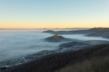 Blick vom Breitenstein, Ochsenwang, Schwäbische Alb auf die drei Kaiserberge - Hohenstaufen, Stuifen und Rechberg. Im Vordergrund die Limburg bei Weilheim Teck im Winter zum Sonnenaufgang mit Nebel.