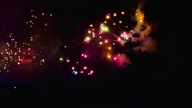 4K. loop seamless of real fireworks background golden shining fireworks with bokeh lights in the night sky. glowing fireworks show. New year's eve fireworks celebration multiple colors in bangkok