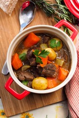 Homemade Beef Stew with Carrots, Potatoes, and Fresh Parsley in a Rustic Dutch Oven