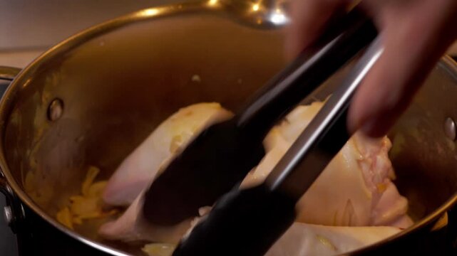 vid&eacute;o en plan fixe avec de la cuisine, autour d'un pied de veau, retournement des deux morceau d'un pied de veaux, avec ustensile de cuisine, avec zoom arri&egrave;re sur le plan vid&eacute;o