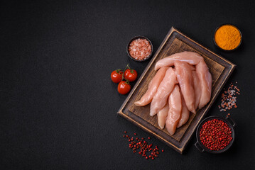 Raw chicken fillet cut into strips with spices and herbs © chernikovatv
