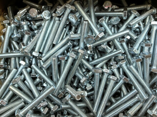 Metallic bolts scattered across a workshop surface at mid-day