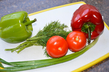 fresh vegetables, ingredients for salad on the kitchen board. ripe bell peppers, tomatoes, green onions and a small bunch of dill. proper nutrition. vegetarianism. diet and healthy lifestyle