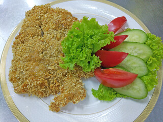 chicken fillet schnitzel, breaded with fresh vegetables. cucumber, tomato and lettuce. fresh vegetables and meat. proper and healthy nutrition. diet