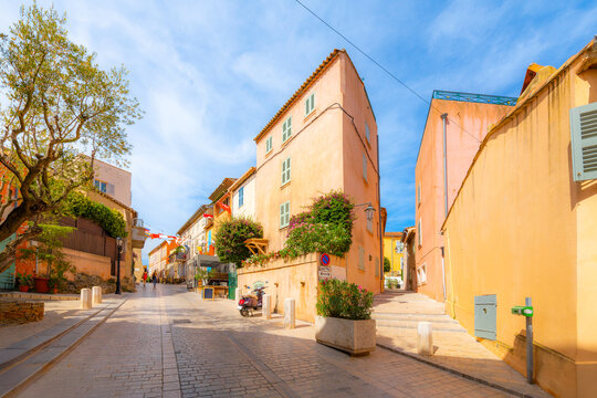 Fototapeta Colorful shops and cafes line the narrow, hilly alleys and streets in the old town of Saint-Tropez, France, along the Cote d'Azur French Riviera.
