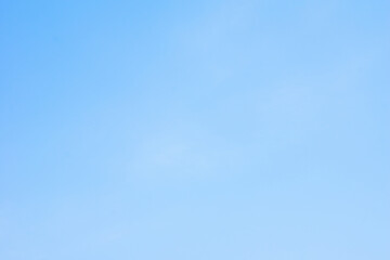 Bright blue sky with soft clouds over a peaceful landscape at midday