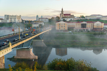 Panoramic view of the city on a sunny summer day. A road bridge crosses the river in the city.