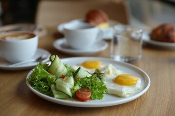 Delicious breakfast served on wooden table in cafe, closeup