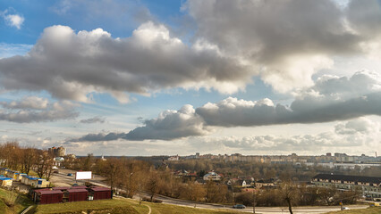 Panoramic view of the city on a sunny summer day. A road bridge crosses the river in the city.