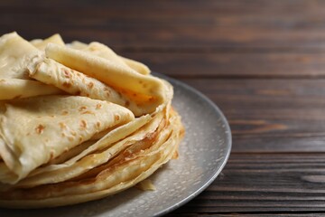 Tasty crepes on wooden table, closeup. Space for text