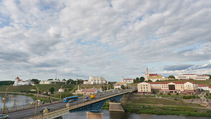 Panoramic view of the city on a sunny summer day. A road bridge crosses the river in the city.