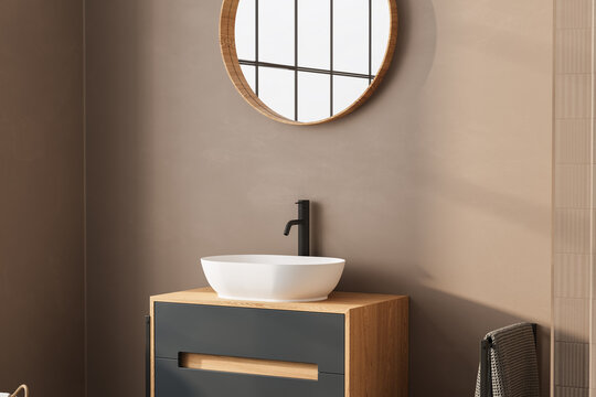 A stylish bathroom vanity with a round white basin on a wooden countertop, paired with a circular mirror. The close-up highlights clean lines and a minimalist approach to modern bathroom design.