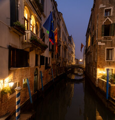 Venetian canal in the evening. Reflection of the medieval city in the water.