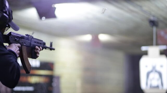 A man shoots a Kalashnikov assault rifle (AK 47) at a shooting range. Sighting in a Kalashnikov assault rifle. A civilian shoots a weapon.