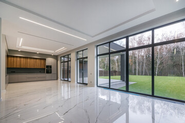 Spacious room in a country house with panoramic windows and a view of the courtyard. White tiled...