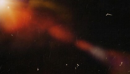 Abstract cinematic bokeh texture with warm red and orange light flares on a black background, vintage film grain overlay effect