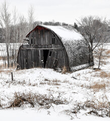 weathered old wood barn in the winter snow