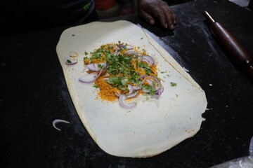 The making of egg stuff paratha with chopped onion, green chilli, coriander leaves