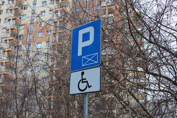 Accessible parking sign in a residential area surrounded by trees