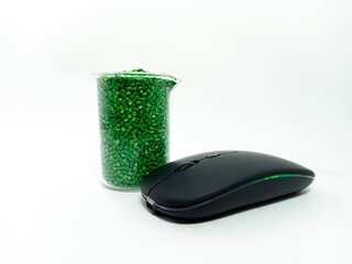 green masterbatch, polymer carries pigment in a container with isolated glass mouse on white...