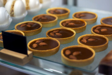 Delicious almond tartlets displayed in a dessert showcase at a bakery