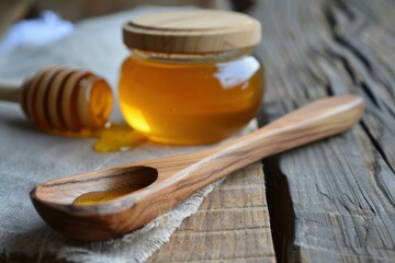 Fototapeta premium Golden honey dripping from wooden dipper and spoon with honey jar on rustic wooden table, creating a sweet and natural scene