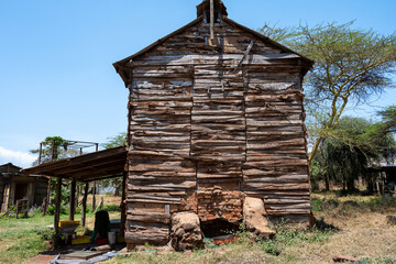 Obraz premium Rustic wood farm building large rocks and brick foundation, split log wood walls, agriculture production on a community farm, Lewa, Kenya, Africa 